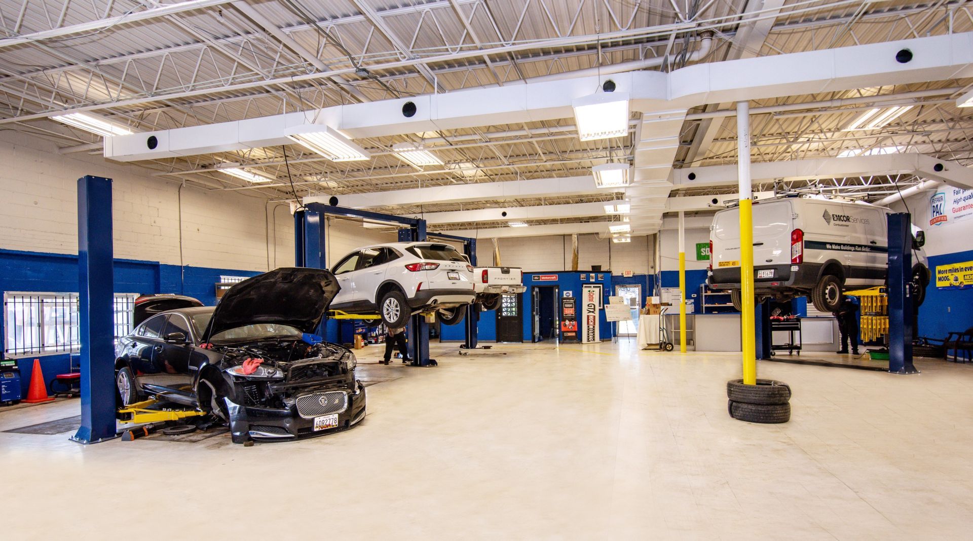 Car repair shop with vehicles on lifts, mechanics working, and bright interior | Freestate Auto & Truck Service