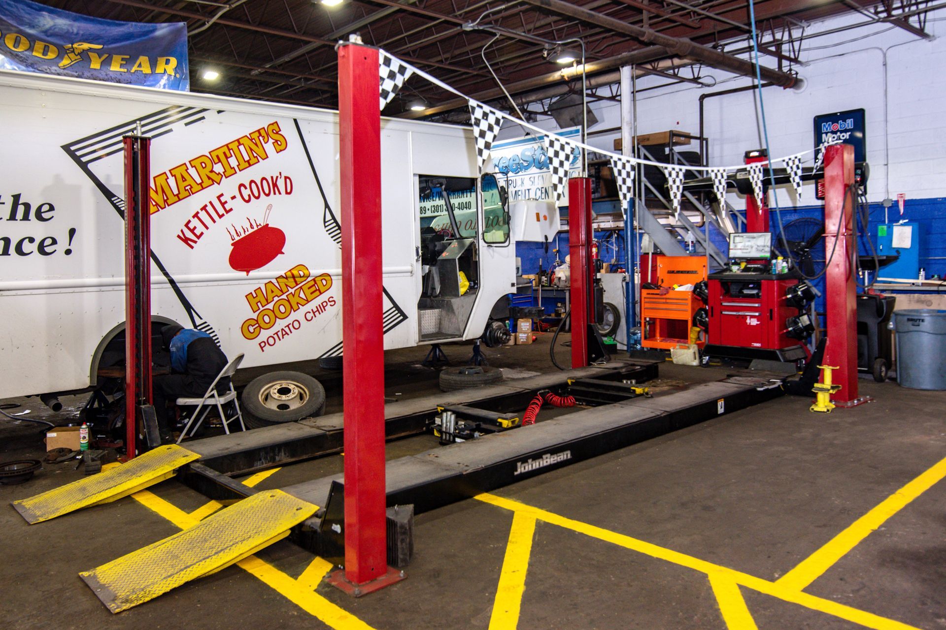 An auto repair shop with a vehicle on a lift, a food truck, and tools | Freestate Auto & Truck Service