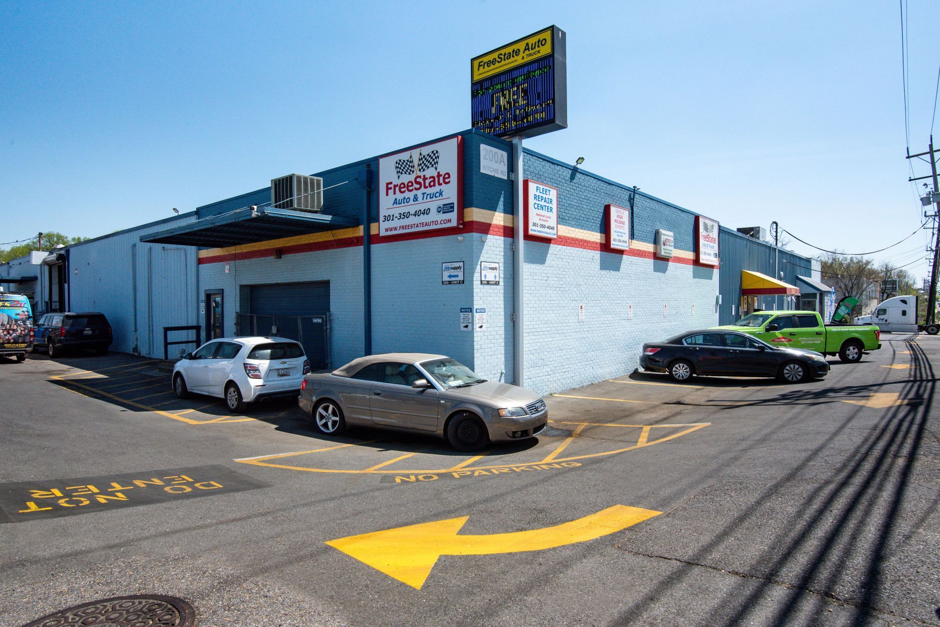 Exterior of a blue building with cars parked nearby, including a sign that reads 