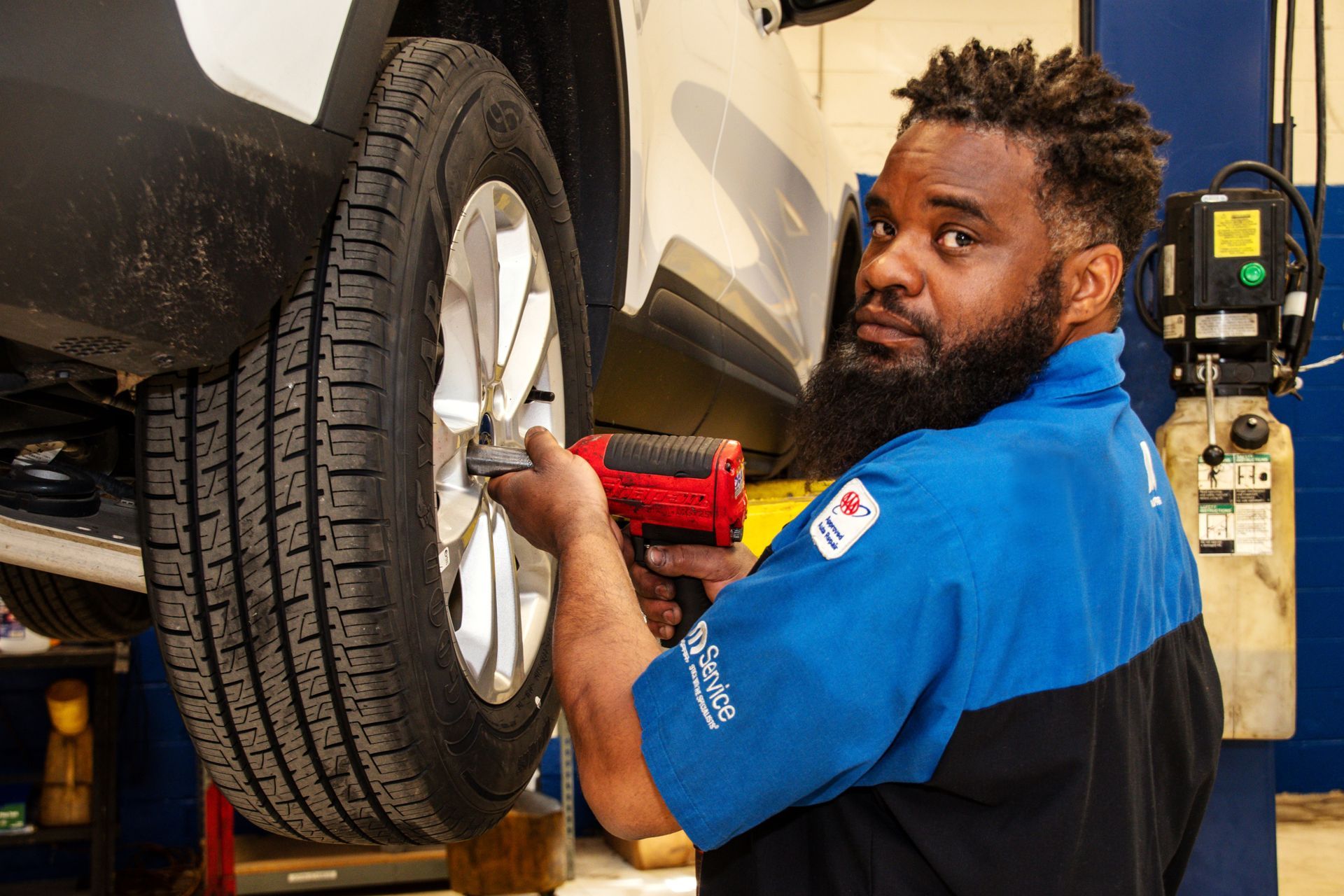 Mechanic using a power tool to remove a car tire in a garage | Freestate Auto & Truck Service