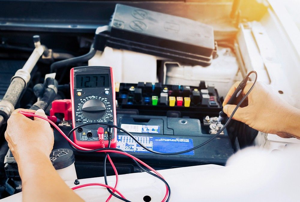 A Person is Using a Multimeter to Test a Car Battery — Raff's Advanced Automotive P/L in Fairy Meadow, NSW
