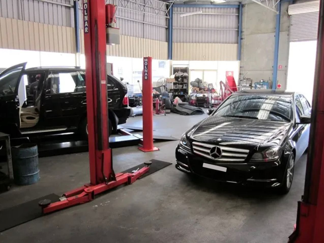 A Black Mercedes is on a Lift in a Garage — Raff's Advanced Automotive P/L in Fairy Meadow, NSW