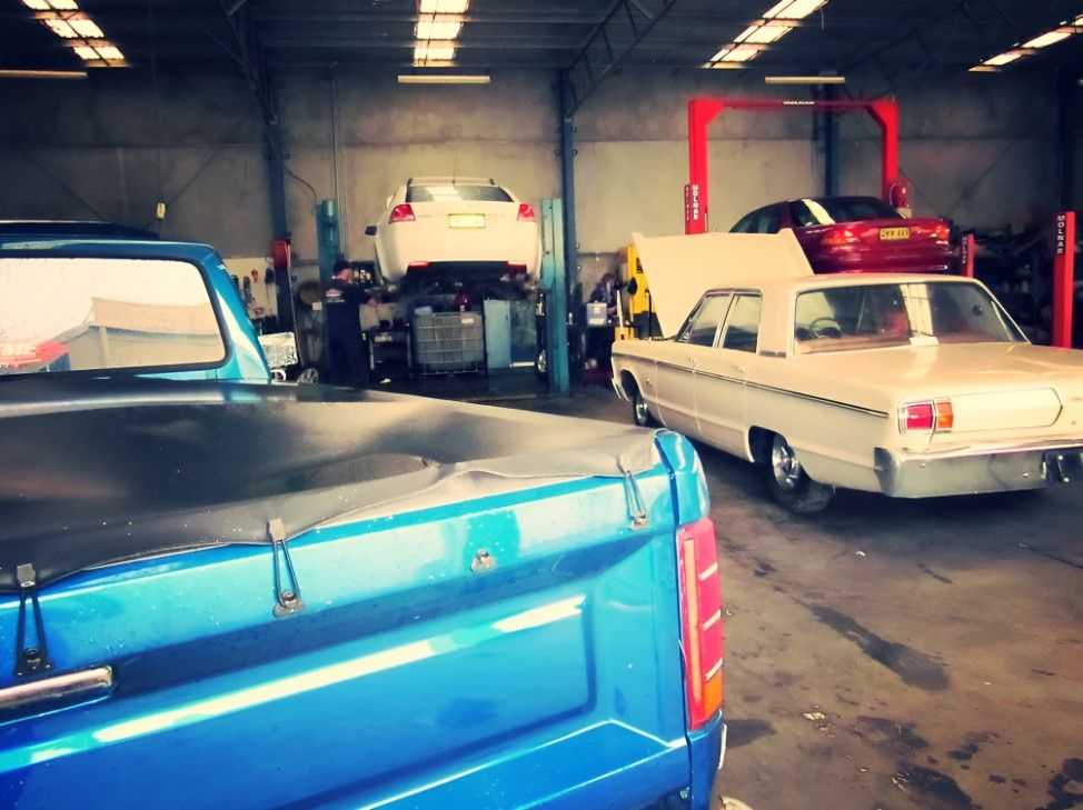 A Blue Truck is Parked Next to a White Car in a Garage — Raff's Advanced Automotive P/L in Fairy Meadow, NSW
