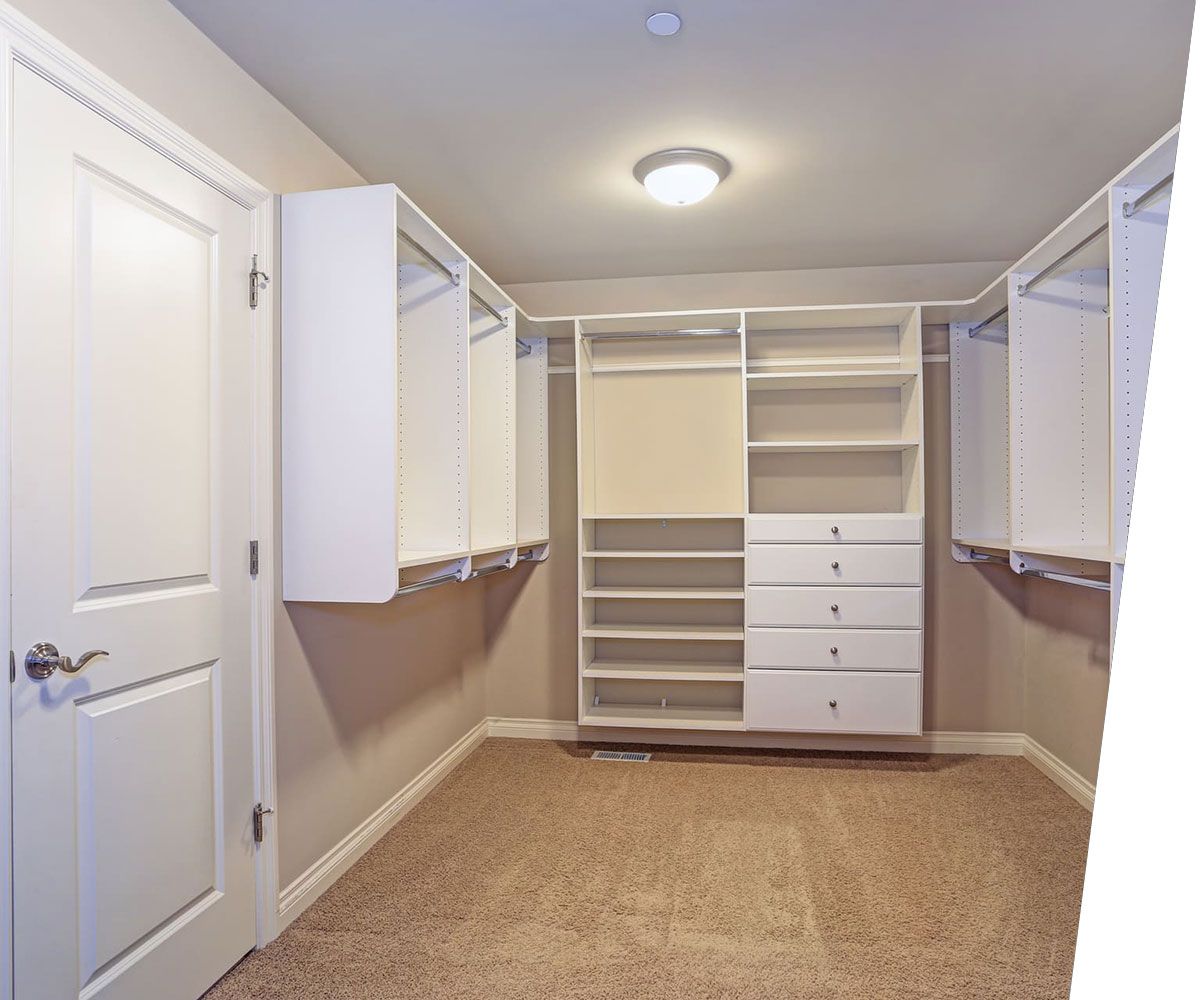 Large walk-in closet with white shelves, drawers
