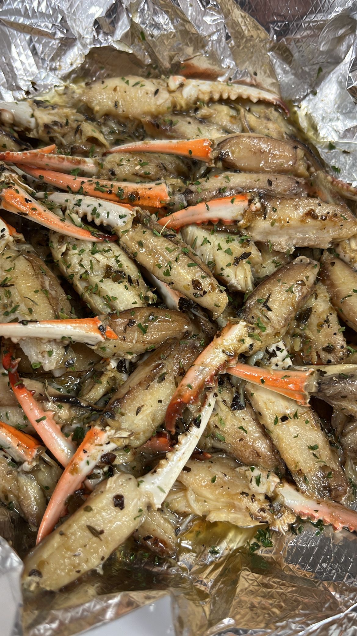 Steamed crab legs in foil with herbs and oil. At High Tide Harry's
