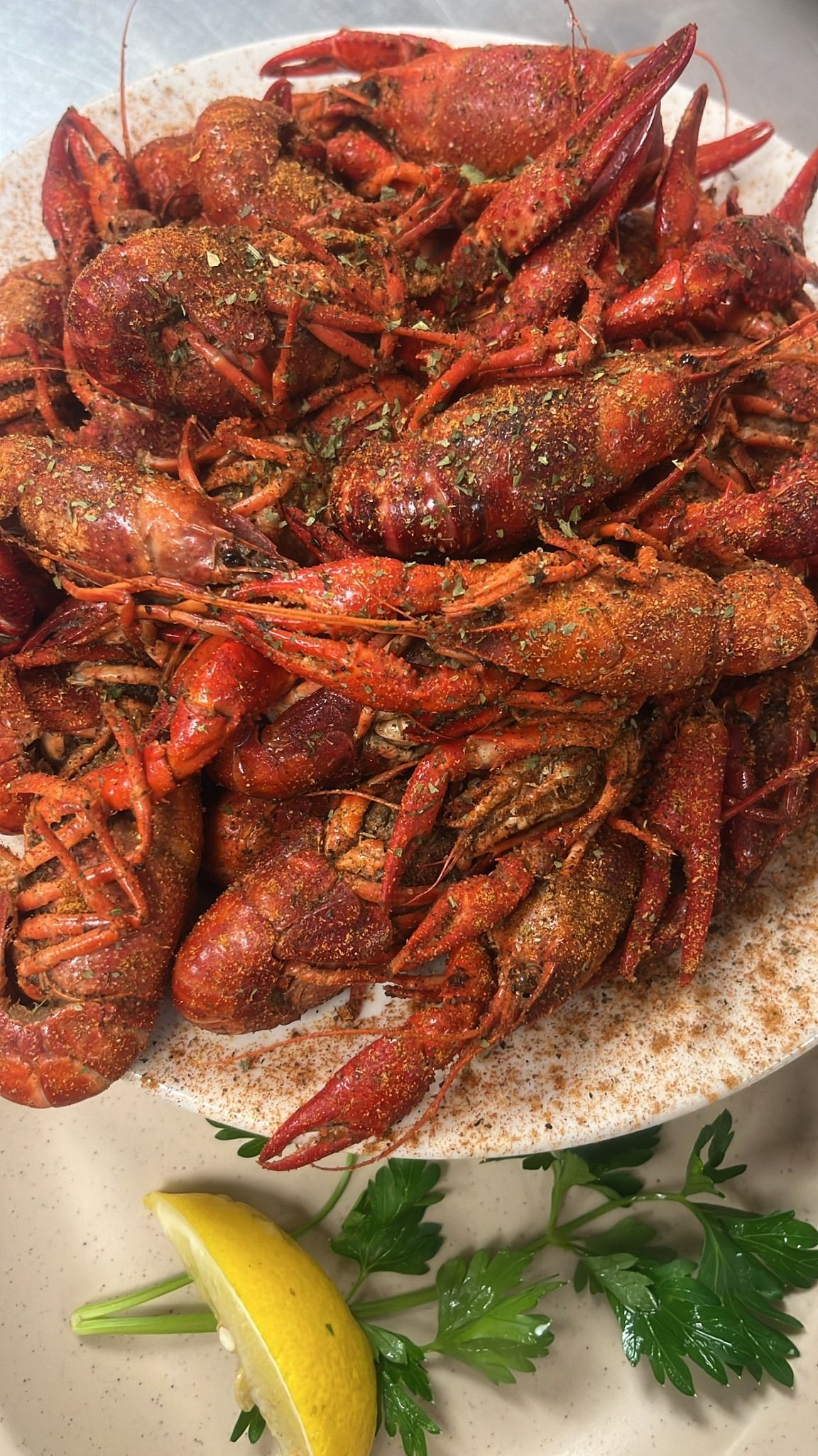 Plate of cooked crawfish, seasoned and garnished with parsley and lemon. At High Tide Harry's