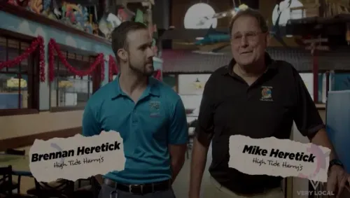 Two men, Brennan & Mike Heretick, stand indoors. Text below them reads 