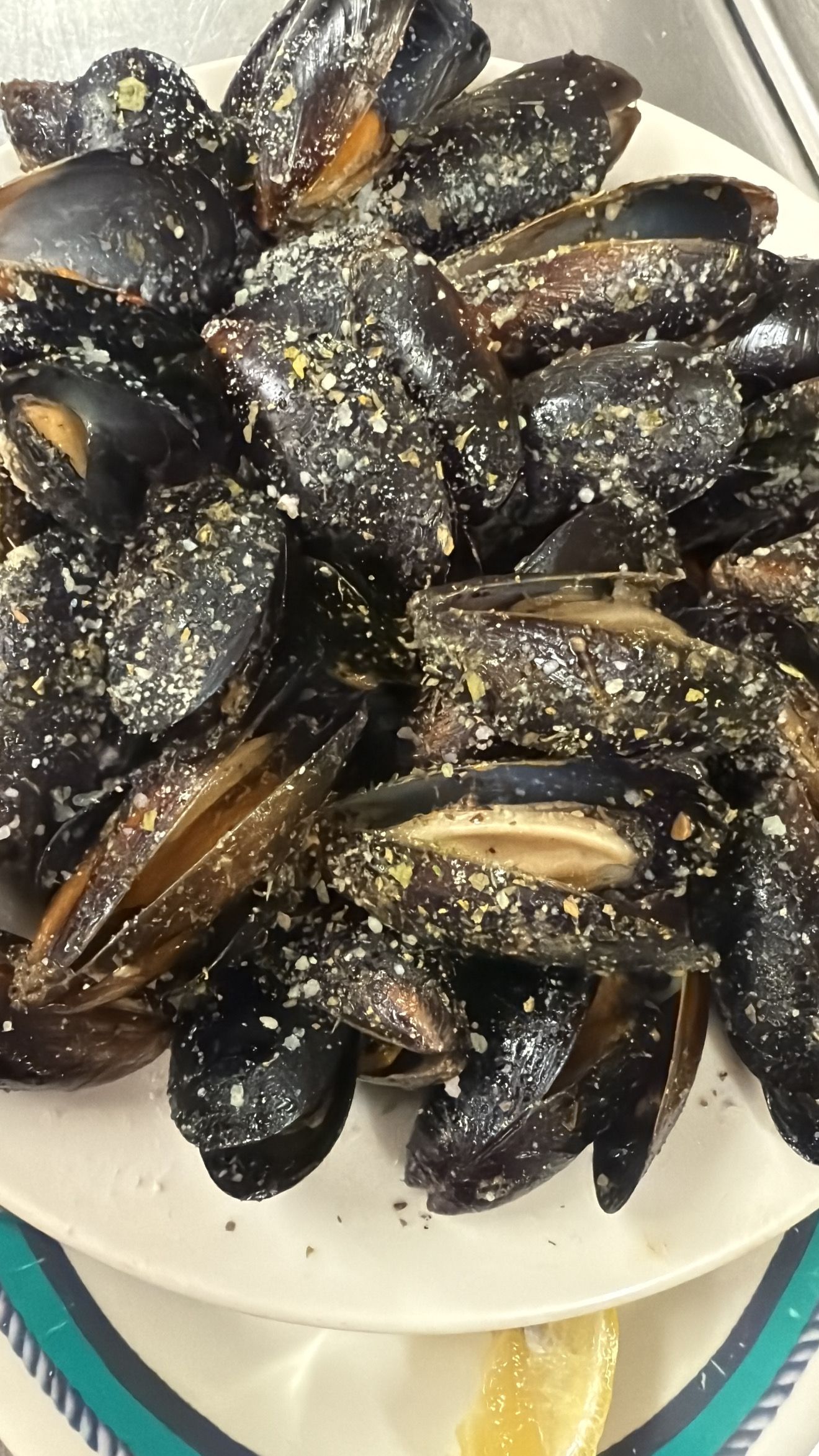 Plate of cooked mussels sprinkled with seasoning. At High Tide Harry's