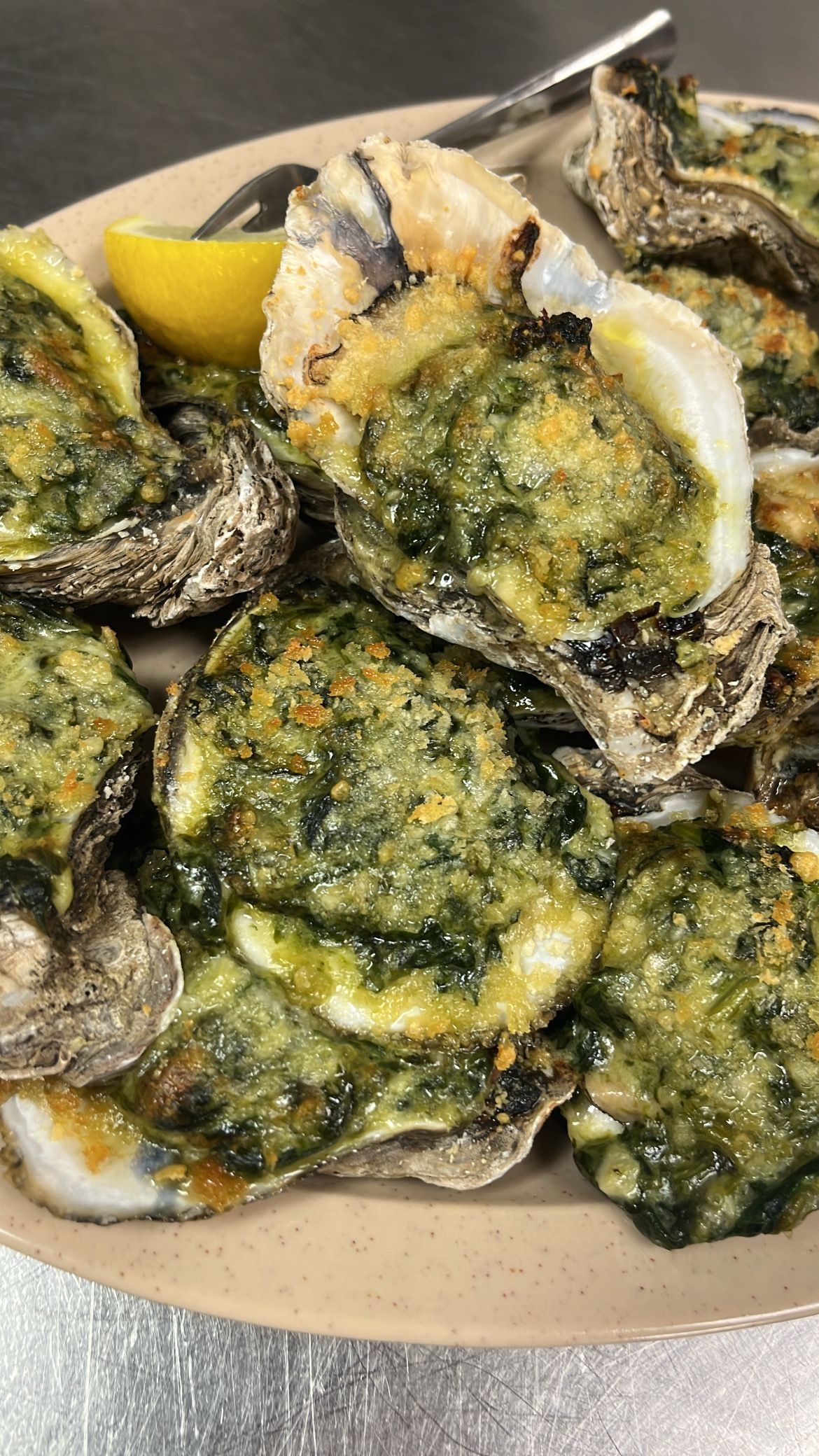 Baked oysters with green topping and lemon wedge. At High Tide Harry's