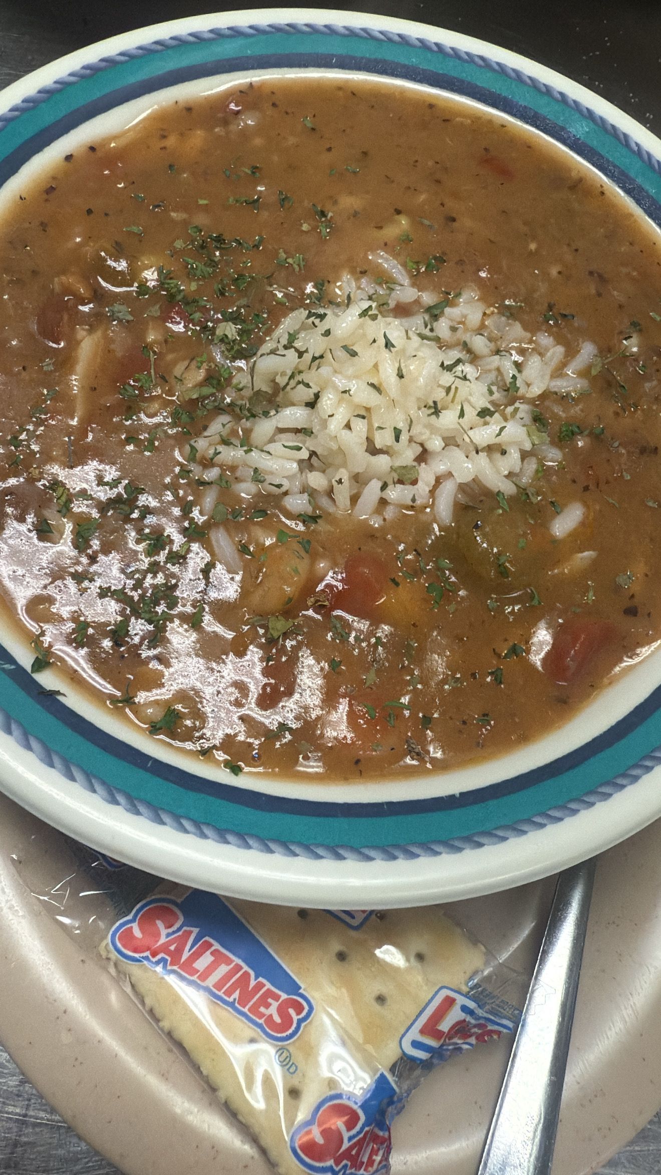 Bowl of gumbo with rice and parsley garnish, served with crackers. At High Tide Harry's