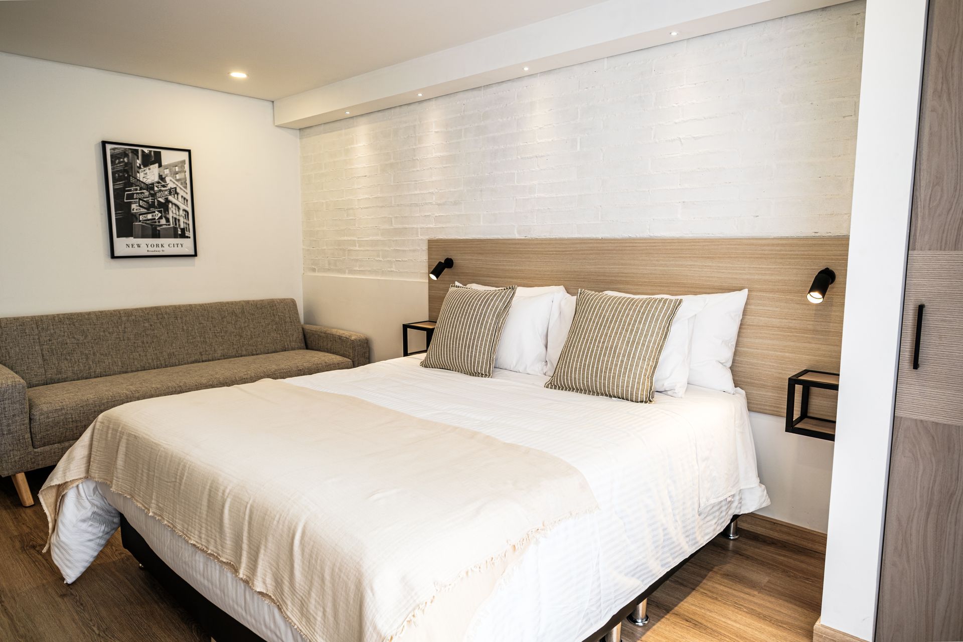Apartasuite con cama doble y ventanal con vista exterior en Nova Iorque, apartasuite en Bogotá.