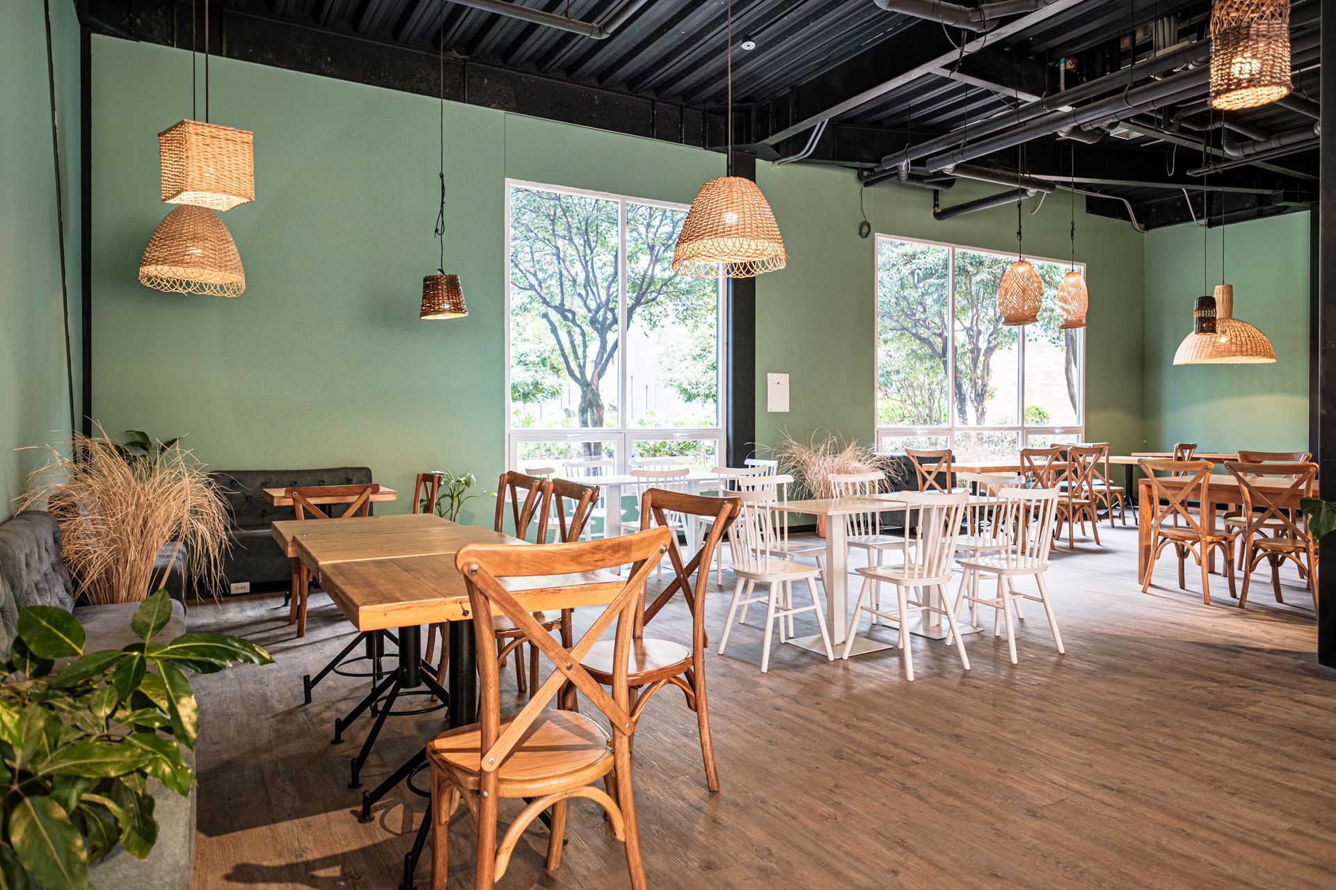 Restaurante de Nova Iorque con mesas de madera y plantas decorativas, hotel con restaurante en Bogotá.