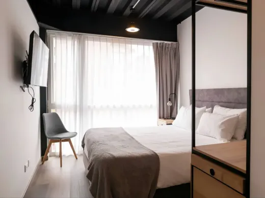 Apartasuite Standard con cama doble, clóset abierto y escritorio en Nova Iorque, apartasuite en Bogotá.
