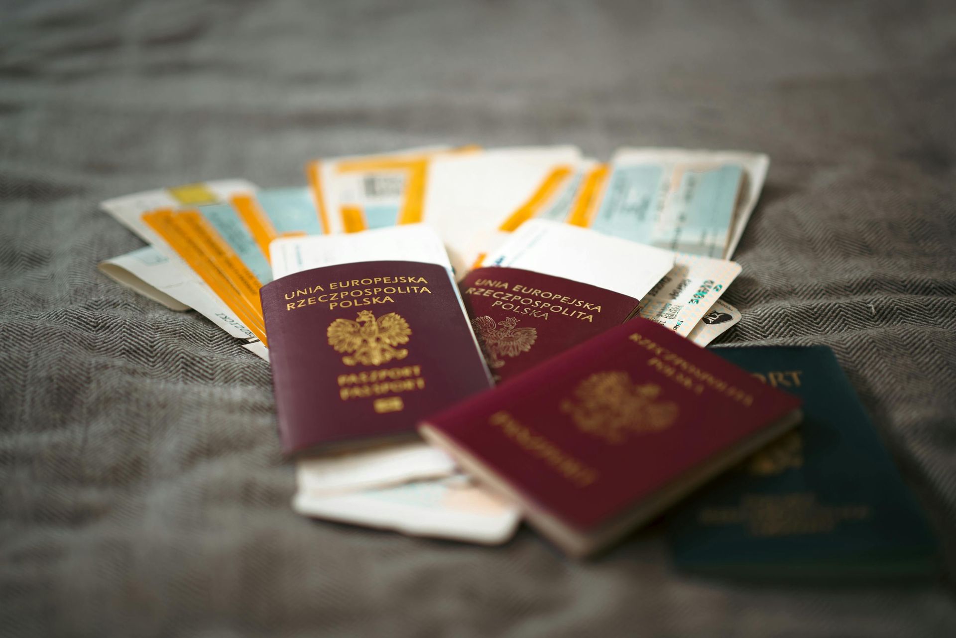Several passports and boarding passes spread on a gray surface.