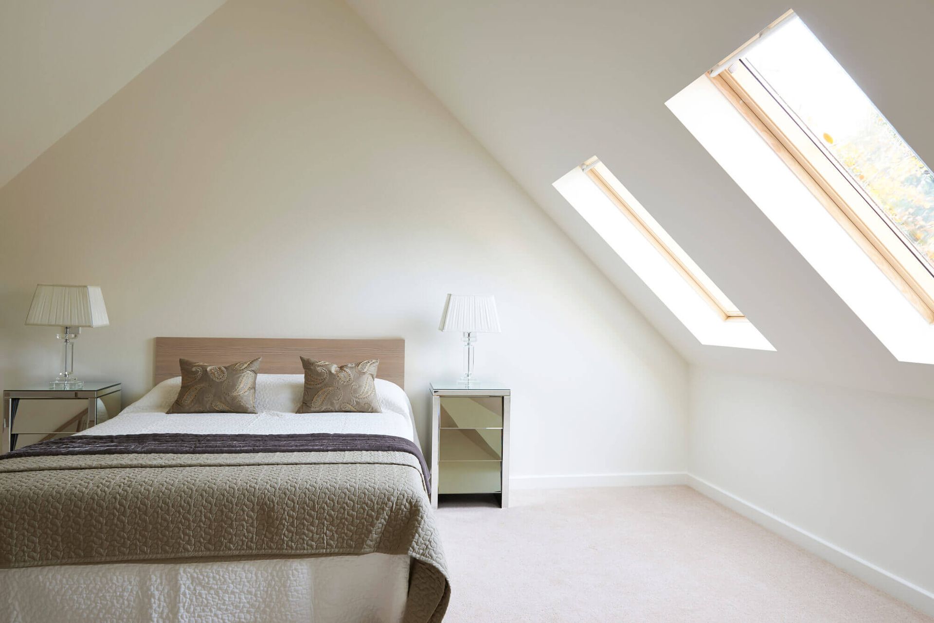 A bedroom with a king size bed and skylights on the ceiling