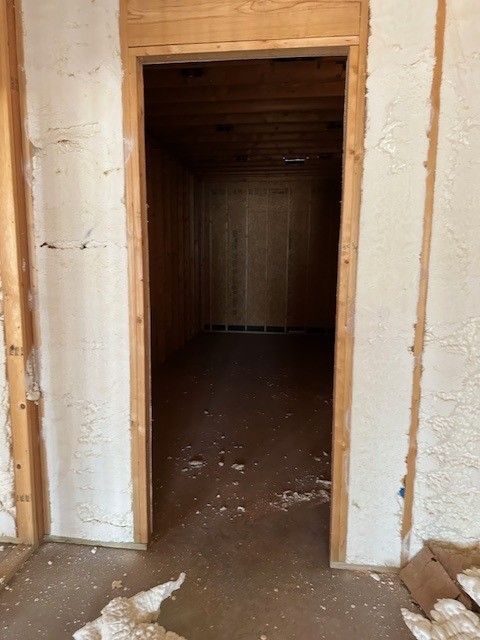 Doorway to a room. Rough, unfinished walls and door frame. Dark, enclosed interior.