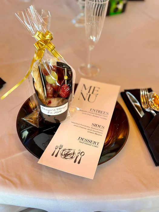 A table with a menu and a cup of food on it.