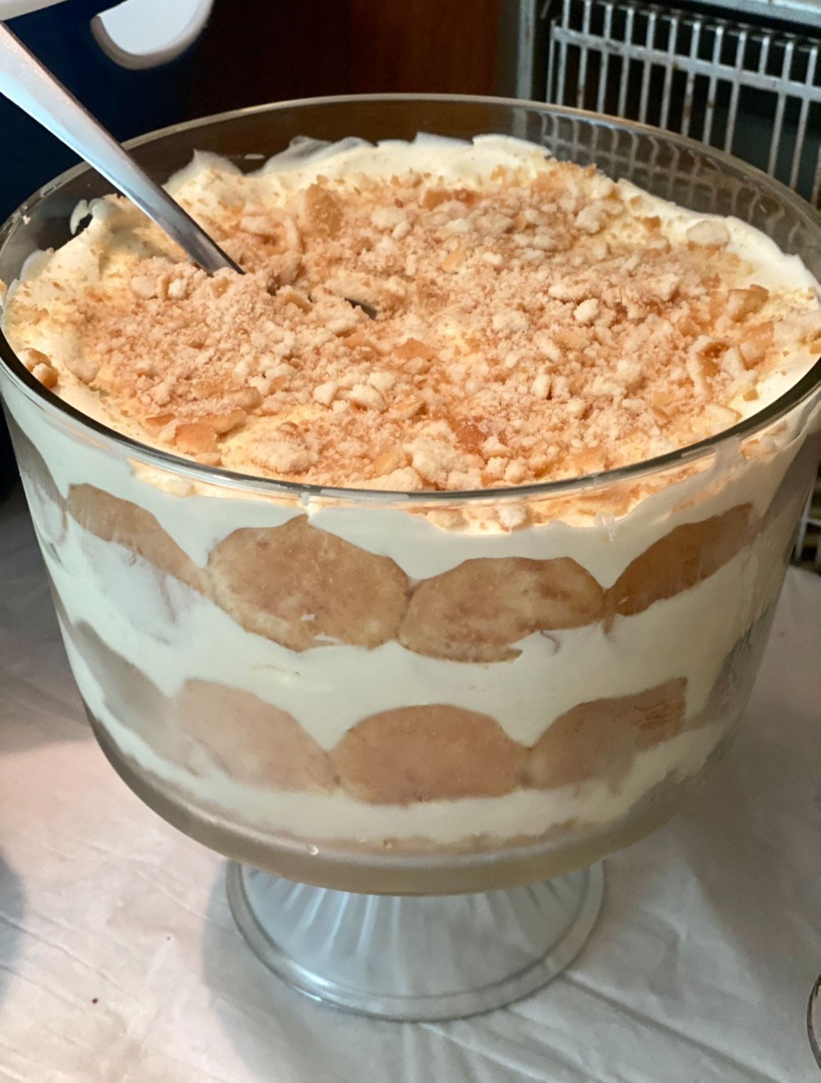 Banana pudding in a glass bowl with a spoon in it