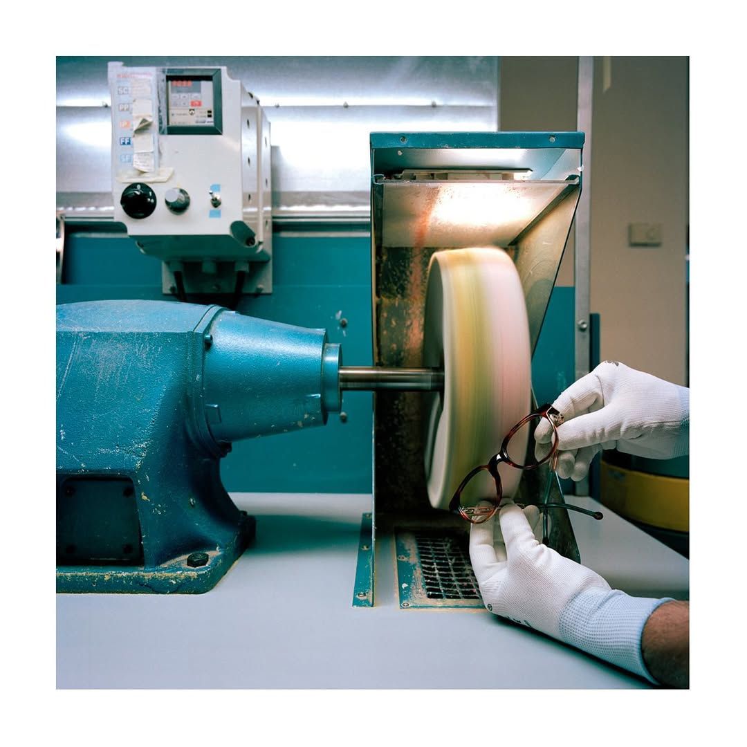 A person is polishing a pair of glasses on a machine