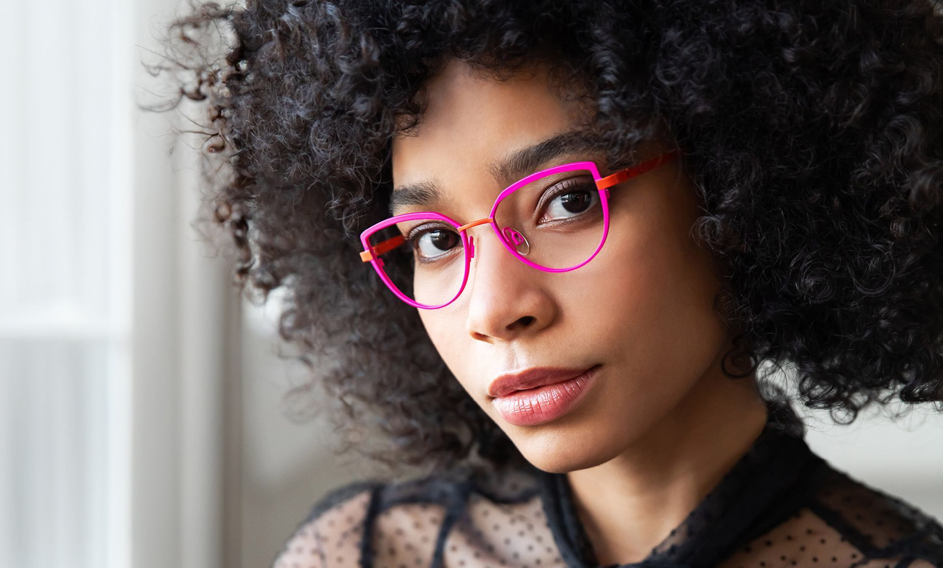 A close up of a woman wearing pink glasses.