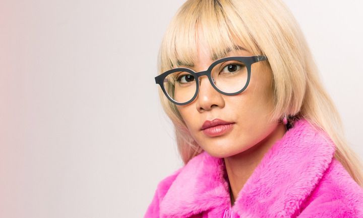 A woman wearing glasses and a pink fur coat.
