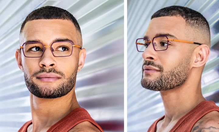 A man with a beard wearing glasses and a red tank top.