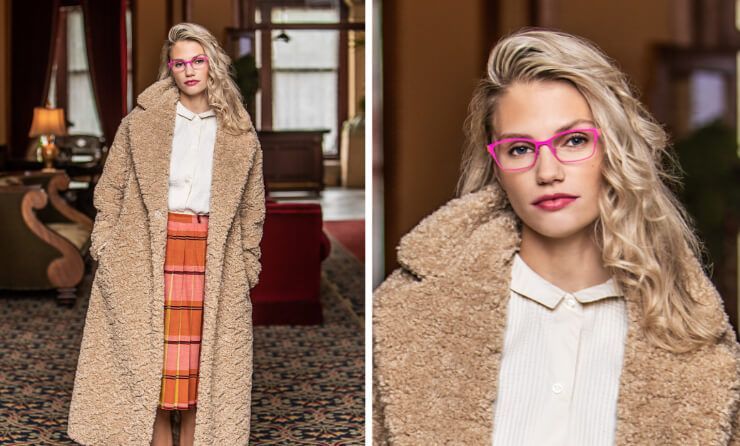 A woman wearing glasses and a teddy bear coat is standing in a room.