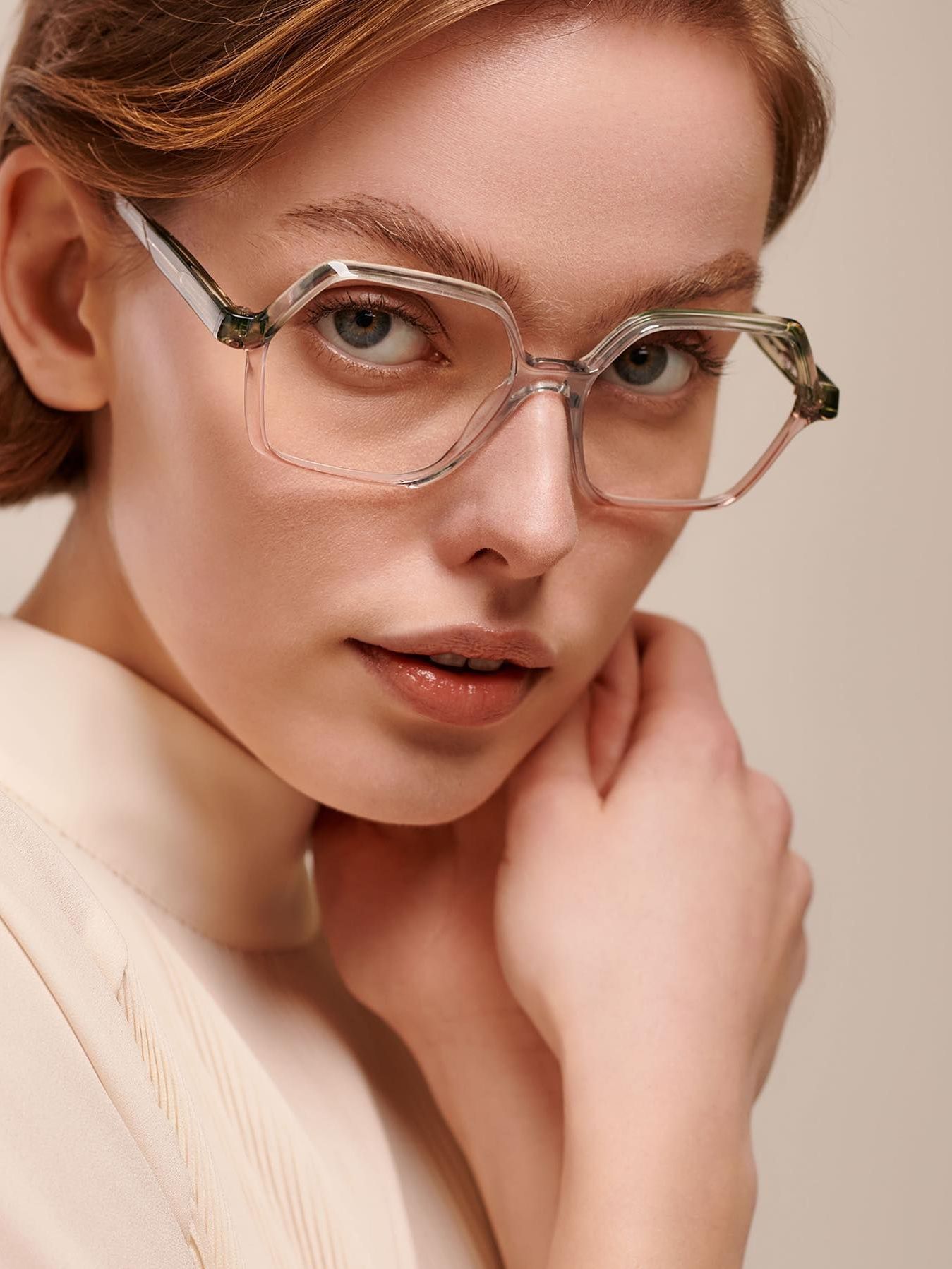 A close up of a woman wearing glasses and a white sweater.