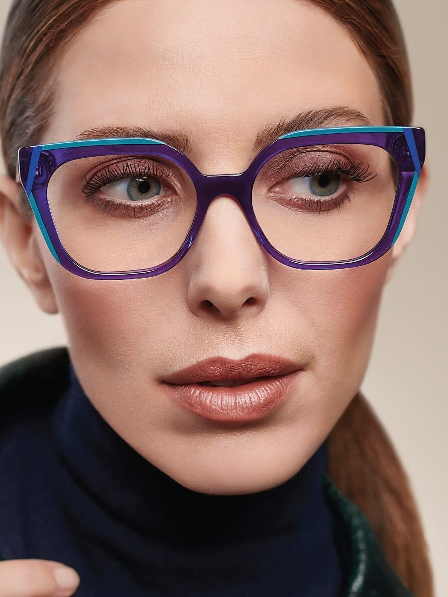 A close up of a woman wearing glasses and a turtleneck