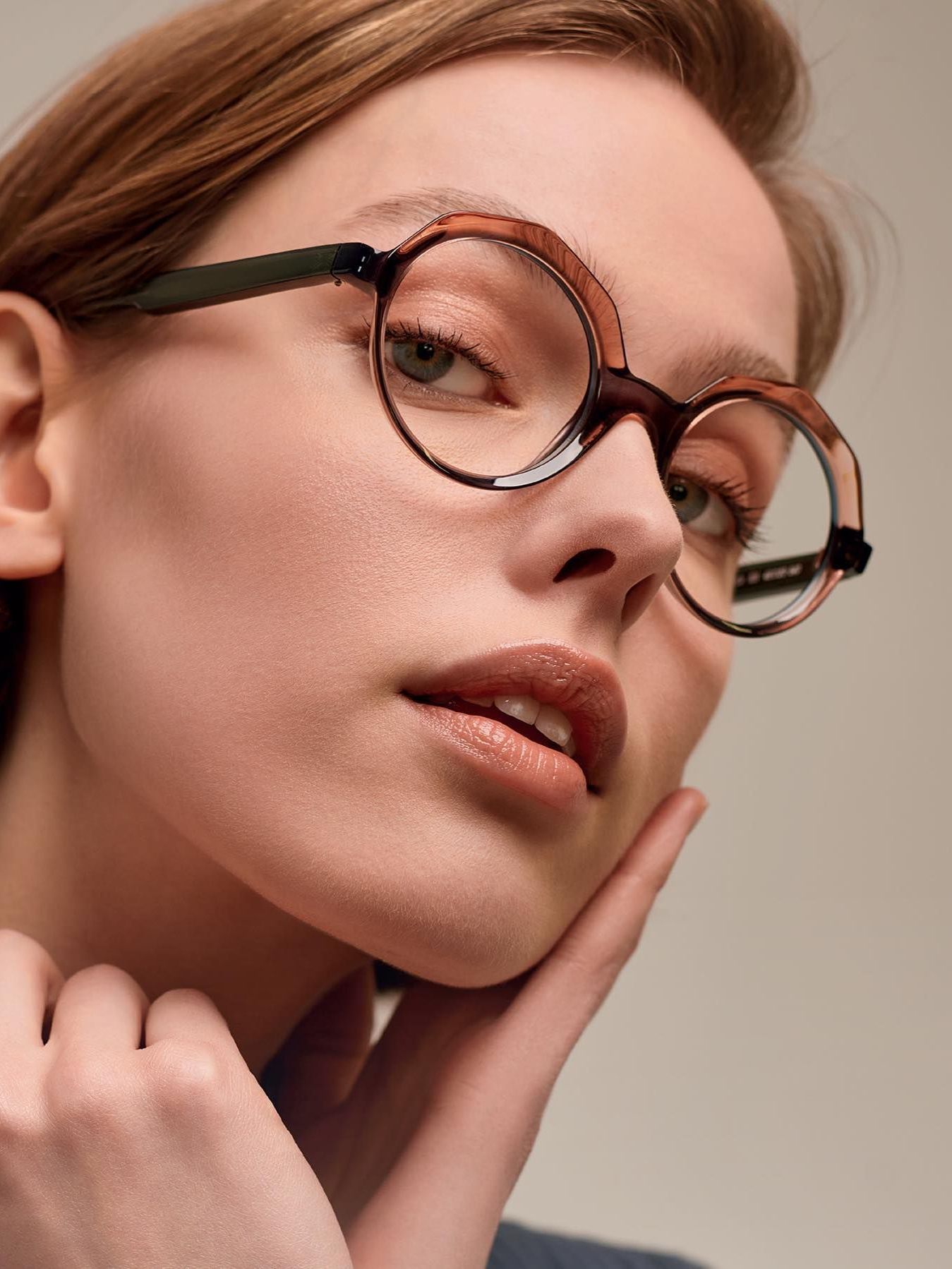 A close up of a woman 's face wearing glasses