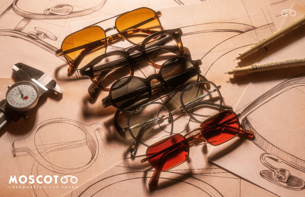 A group of sunglasses are stacked on top of each other on a table.