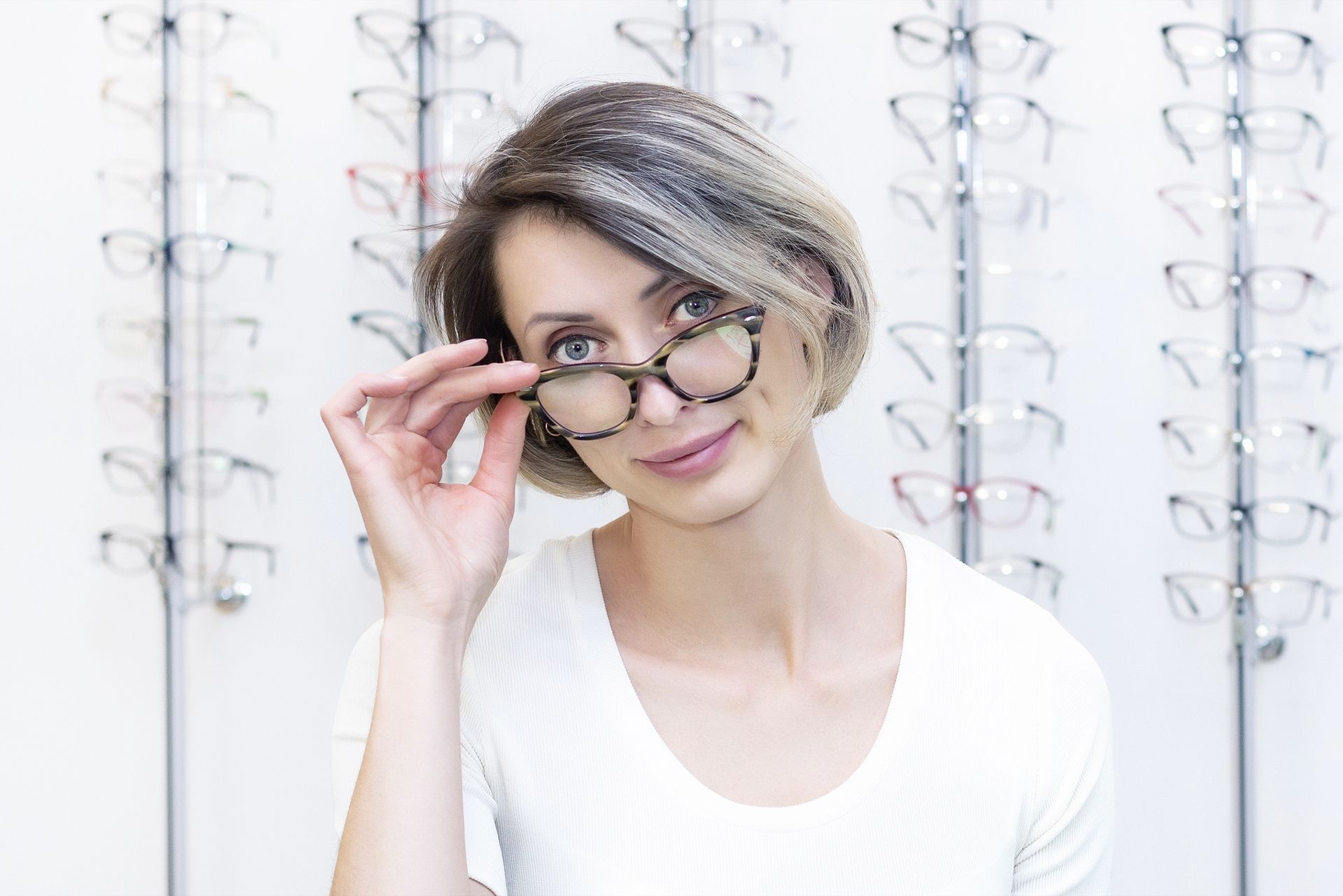 A woman is trying on glasses in an optical store.