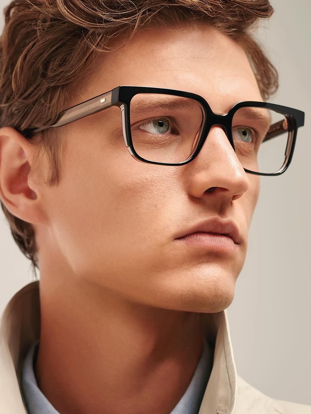 A close up of a man wearing glasses and a jacket.