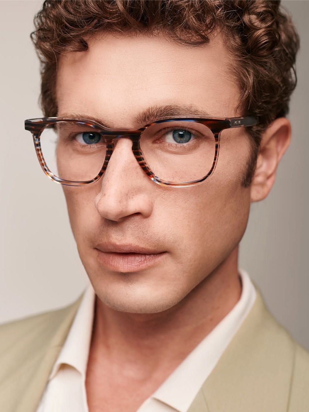 A close up of a man wearing glasses and a suit