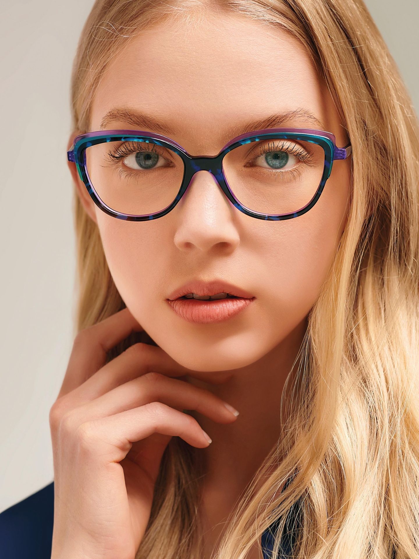 A close up of a woman wearing blue glasses