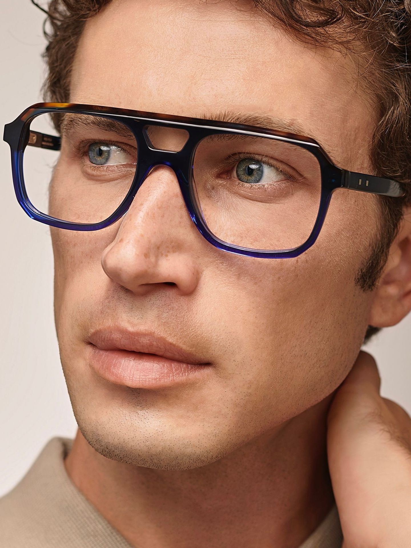 A close up of a man wearing glasses with a blue frame