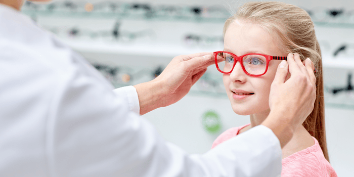 A little girl is getting glasses from an ophthalmologist.