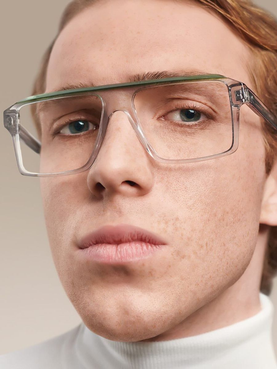 A close up of a man wearing glasses and a white turtleneck