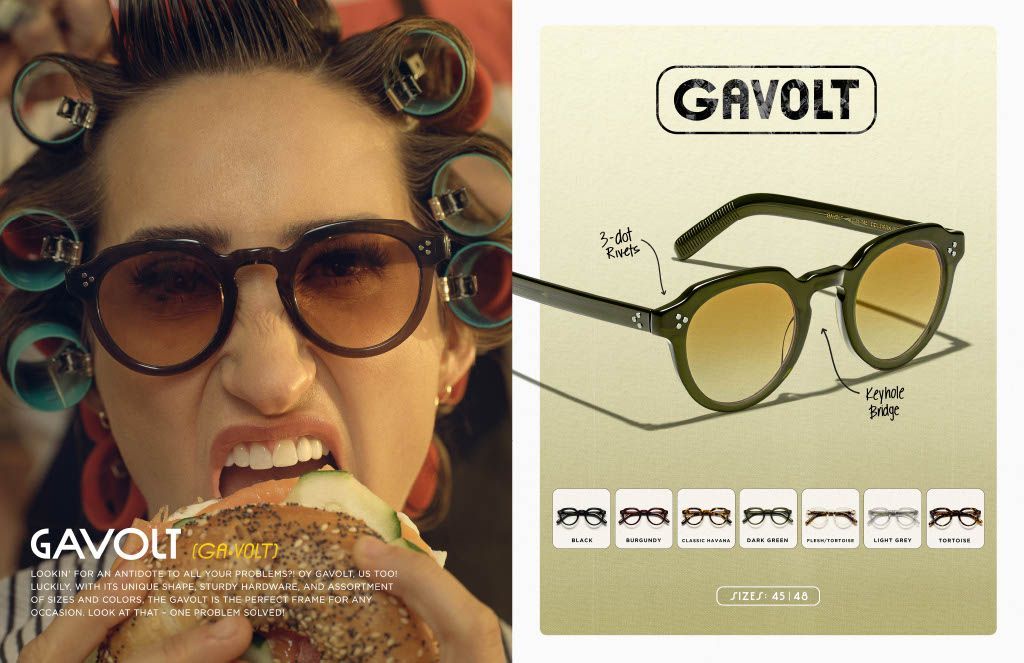 A woman wearing sunglasses is eating a hamburger