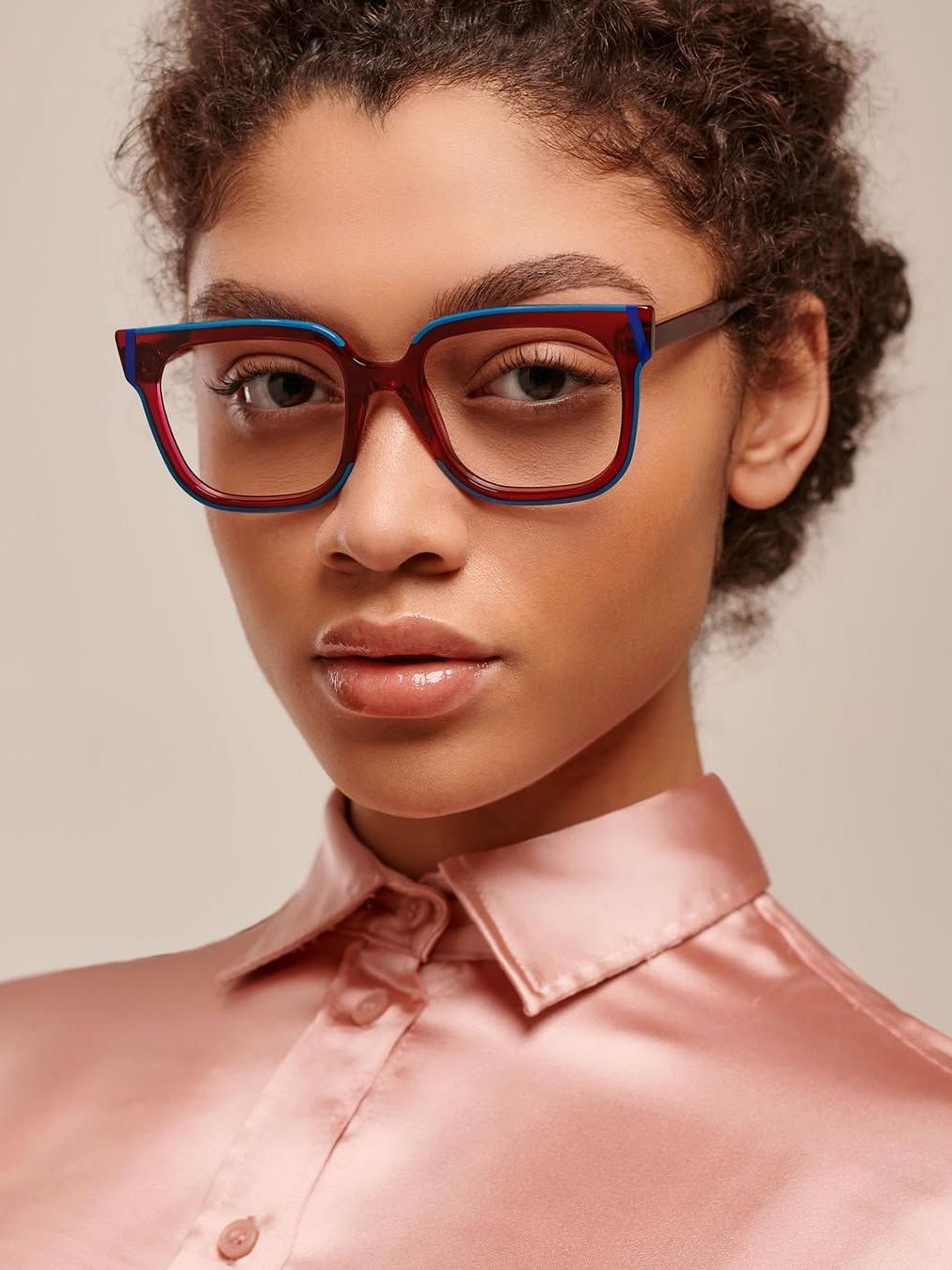 A woman wearing glasses and a pink shirt