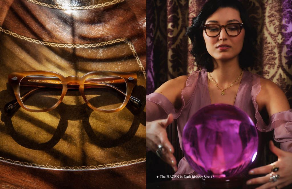 A woman wearing glasses is holding a purple crystal ball