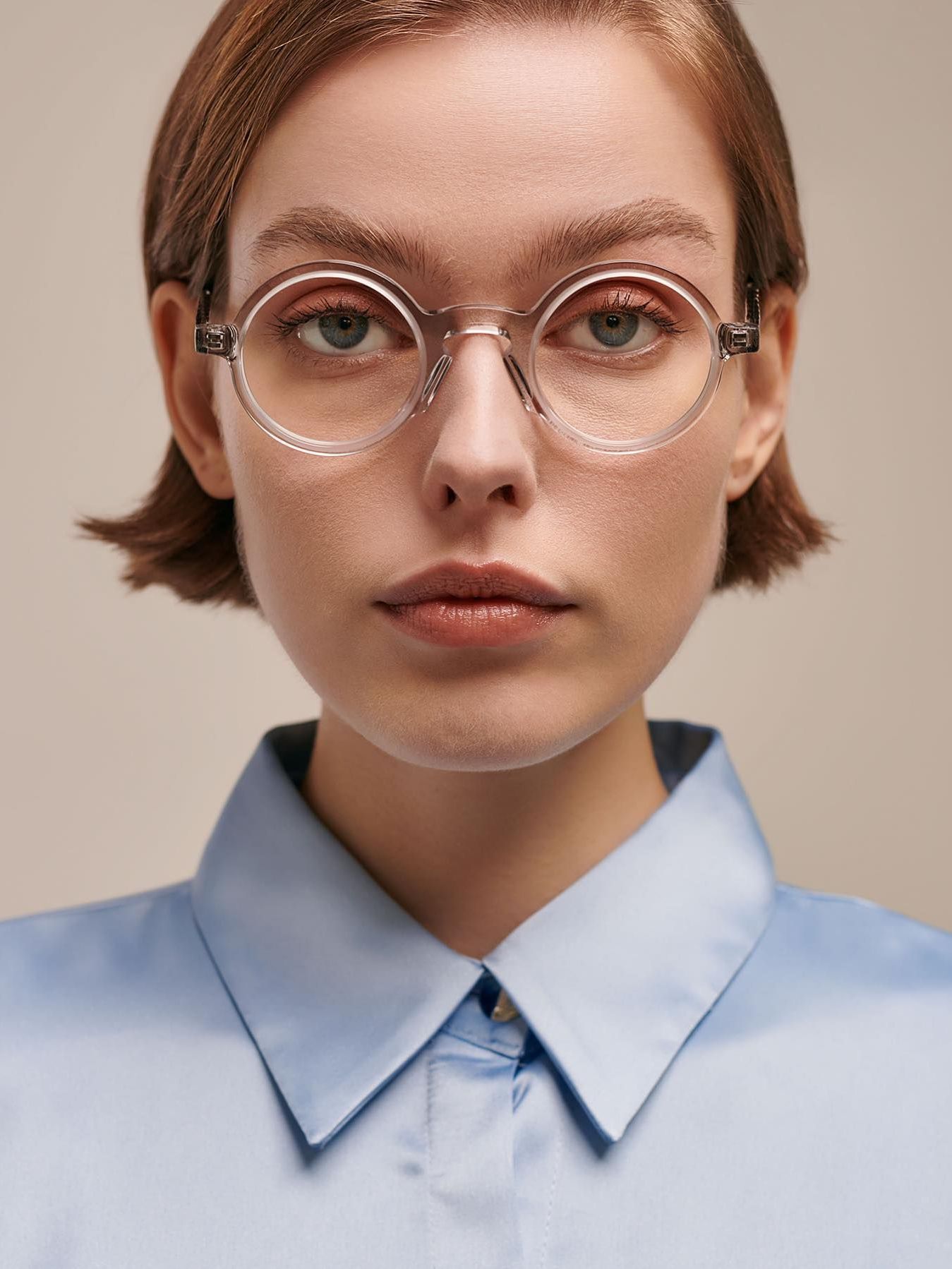 A woman wearing glasses and a light blue shirt