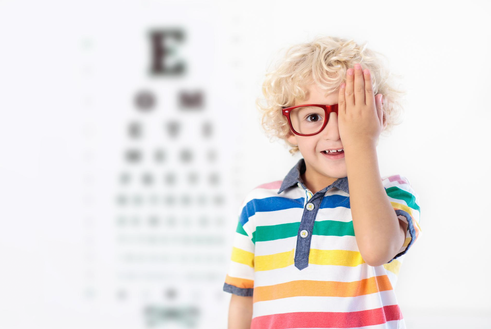 child wearing glasses covering one eye