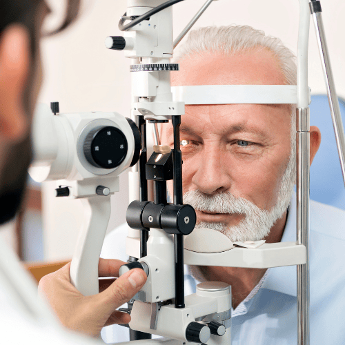 Man having an eye exam with an ophthalmoscope, being examined by a doctor.