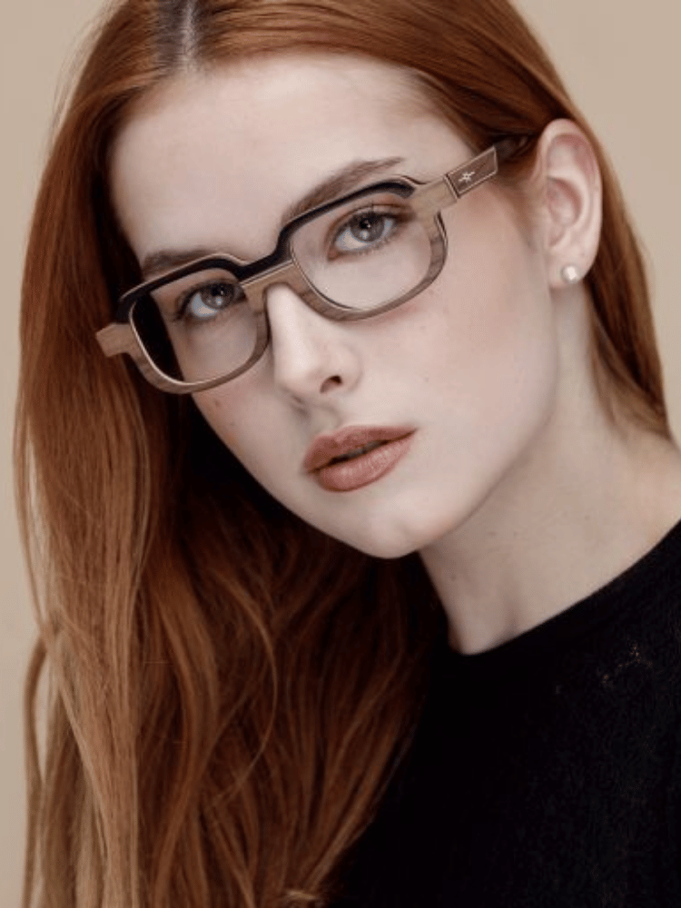 A close up of a woman wearing glasses and a black shirt