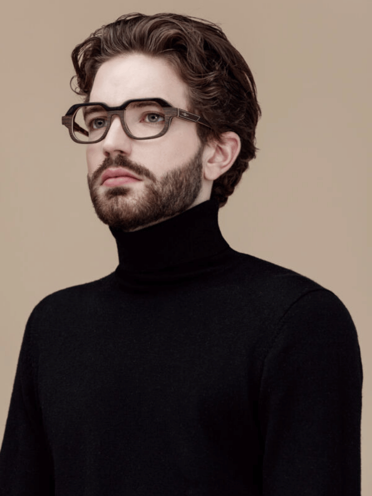 A man with a beard wearing glasses and a black turtleneck