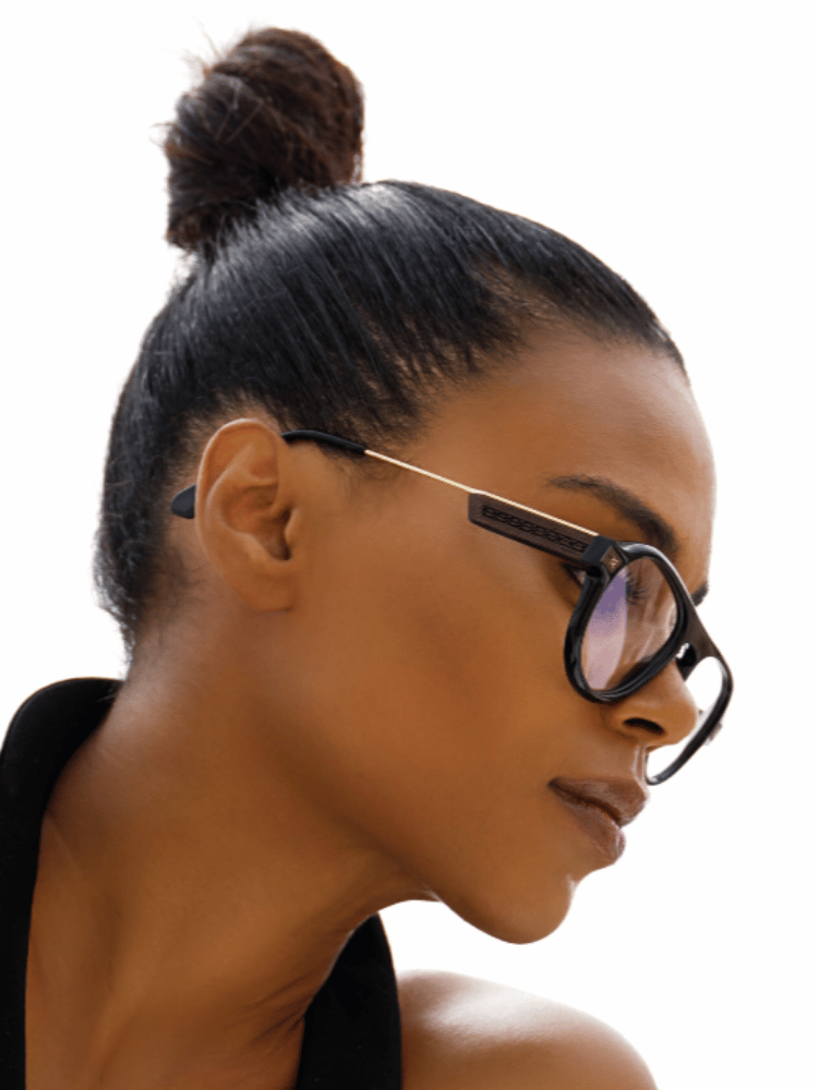 A woman wearing glasses has her hair in a bun