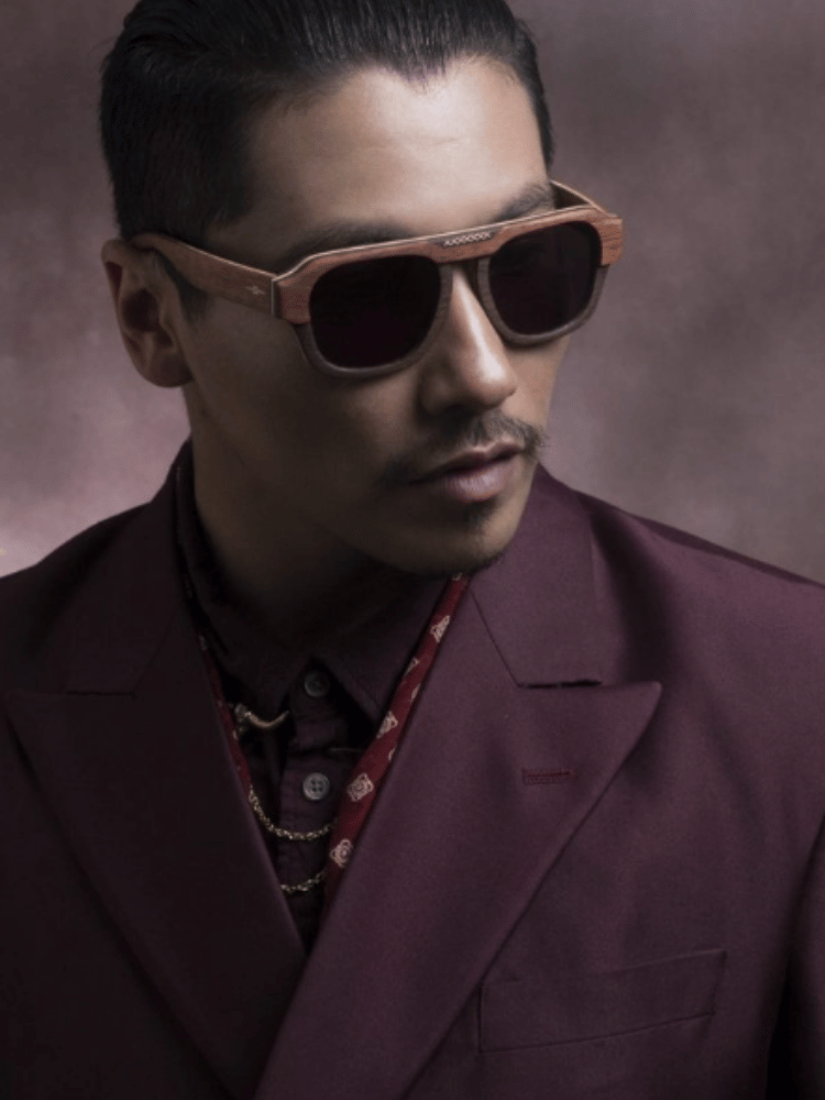 A man wearing sunglasses and a maroon suit