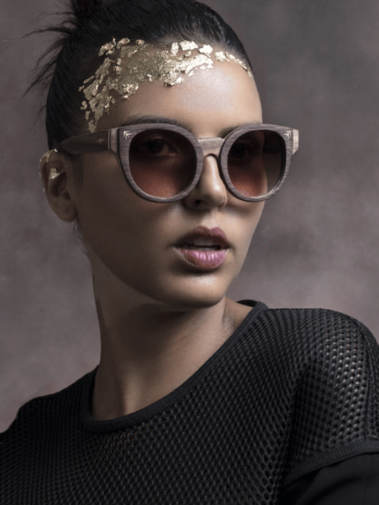 A woman wearing sunglasses and gold leaf on her head