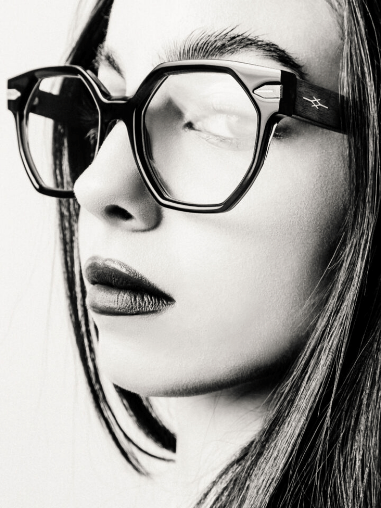 A black and white photo of a woman wearing glasses.